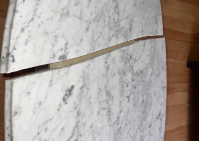 A white marble table is sitting on a wooden floor.